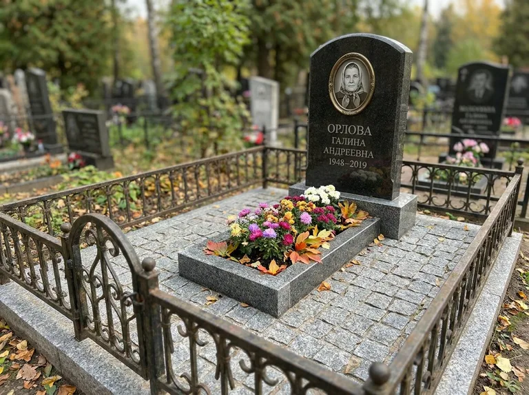 Благоустроенное захоронение с гранитной плиткой, оградой и цветником во Владивостоке