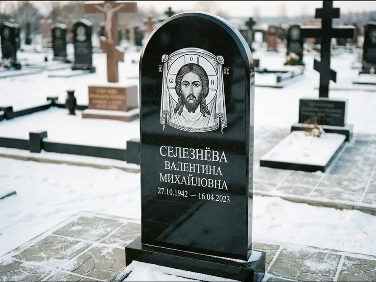 Памятник с гравировкой иконы: небольшая скромная одиночная стела с именной иконой — золочёный нимб на образе, аккуратный участок с газоном, работа «Ковалёв» во Владивостоке