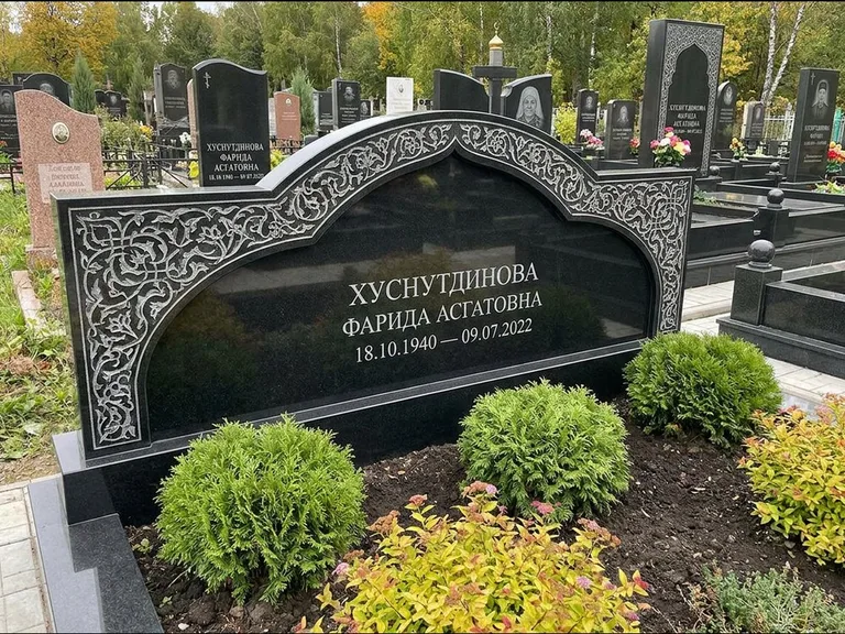 Мусульманский памятник: вытянутая горизонтальная семейная стела с аркой — белая гравировка силуэта мечети с минаретами, участок с декоративными кустами, работа «Зарипова» во Владивостоке