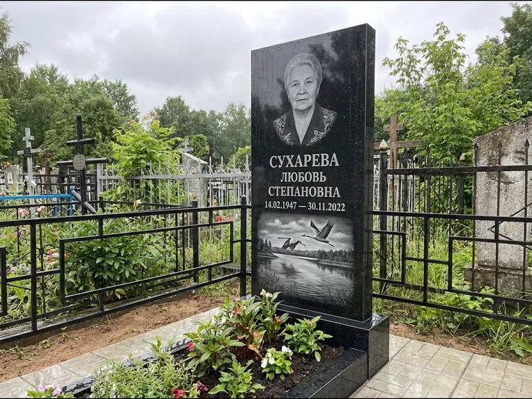 Памятник с гравировкой журавлей — гравировка пары журавлей над гладью озера в нижней части, работа «Сухарева» во Владивостоке