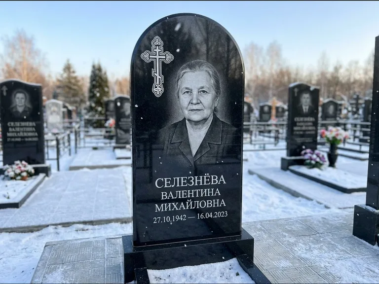 Памятник из чёрного гранита — массивная стела с крестом в лучах с крестом в лучах, работа «Одинцова» во Владивостоке