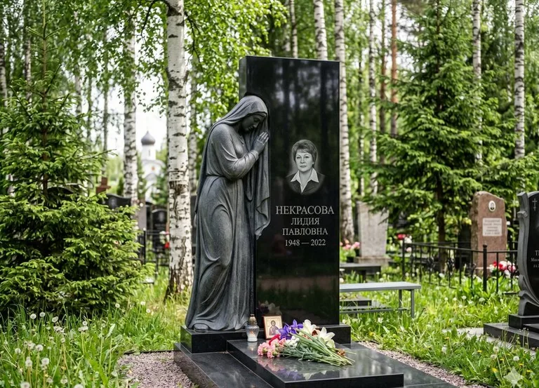 Гранитная фигура скорбящего мужчины у чёрной стелы во Владивостоке