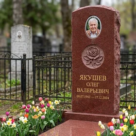 Комбинированный памятник фигурной стелы из красного гранита с цветником